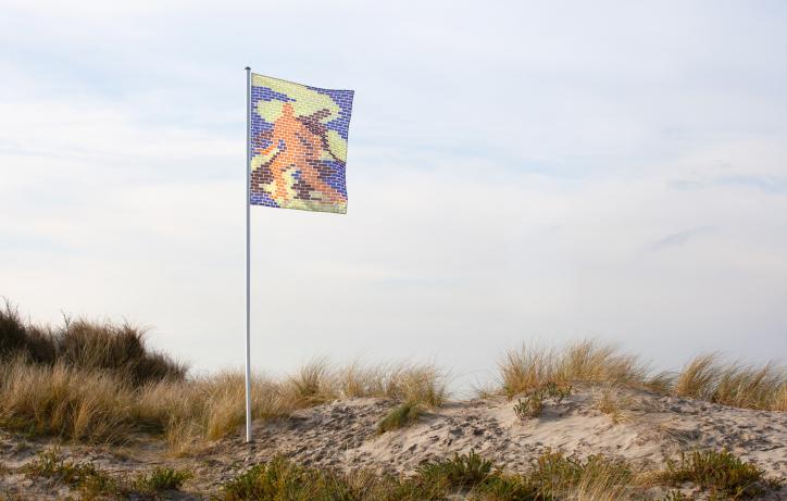 Campagnebeeld Festival van de Architectuur. Een vlag op een vlaggenmast in de duinen. Beeld gemaakt door Telma Lannoo en Tom Callemin